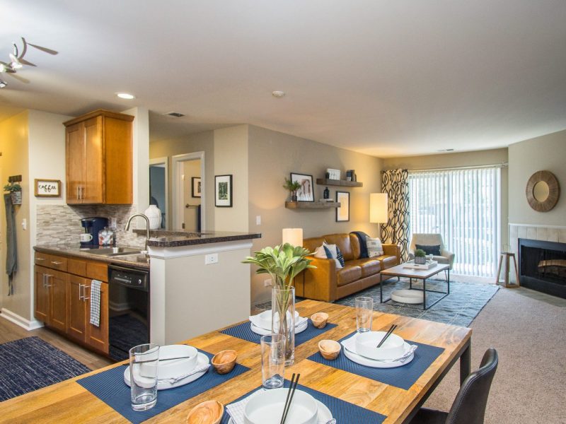 This image shows the Premium Apartment Feature, especially the dining room showcasing a golden-brown and white combination of colors with luxurious pieces of furniture. The dining room was also accessible to the living room and the kitchen island.