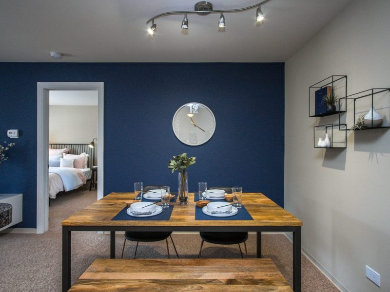 This image shows the Premium Apartment Feature, especially the dining room showcasing light and dark combinations of colors with minimal pieces of furniture.