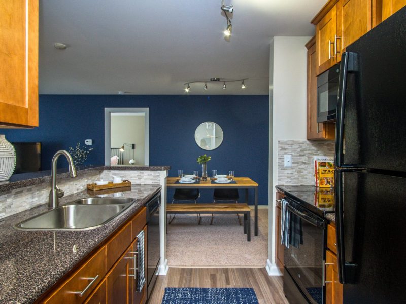 This image shows the Premium Apartment Feature, especially the kitchen island showcasing a neat granite-inspired countertop and an area that is accessible in the dining room.