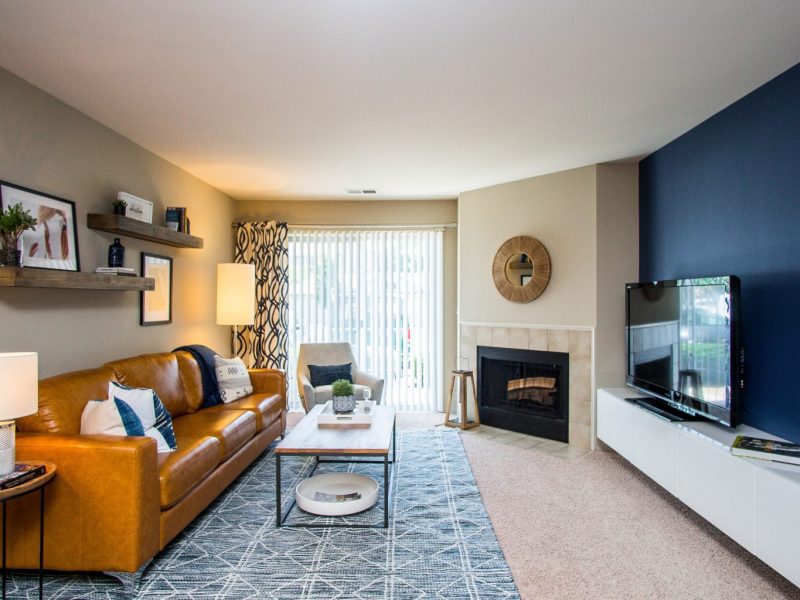 This image shows the Premium Apartment Feature, especially the living room area showcasing a spacious and luxurious interior design with a fireplace beside the private patio.