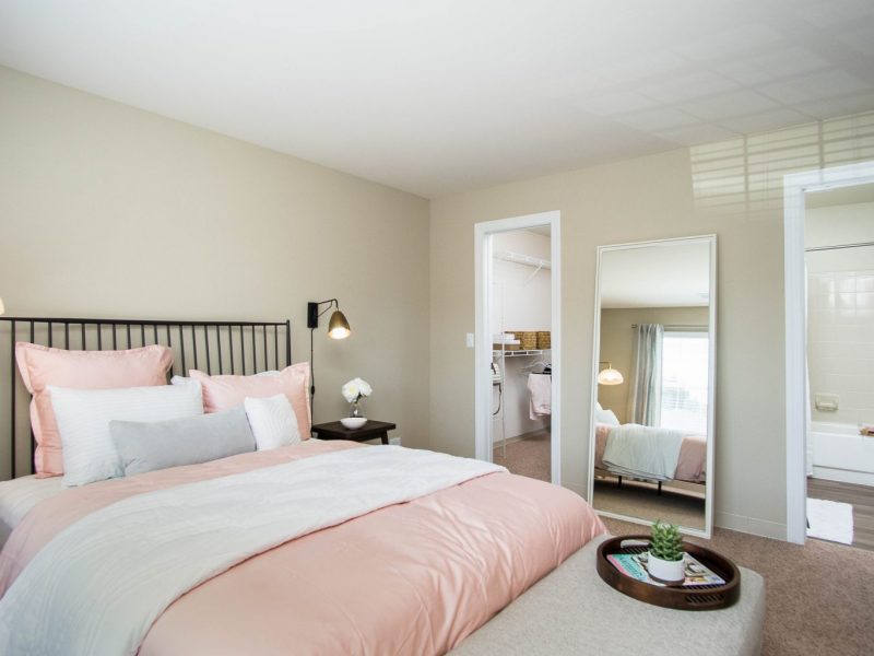 This image shows an expansive view of the Premium Apartment Feature, specifically the bedroom with a touch of pastel and white colors, and the area was accessible to the bathroom and the oversized closet.